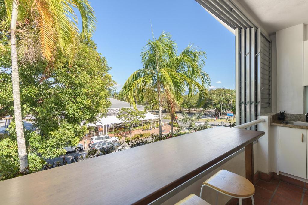 Studio on Macrossan في ميناء دوغلاس: بلكونه فيها طاوله وكراسي والنخيل