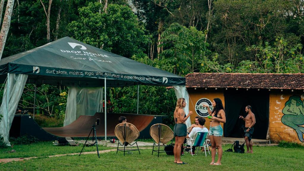 a group of people standing in front of a tent at Drop House Hostel - Surf & Skate - Itamambuca in Ubatuba