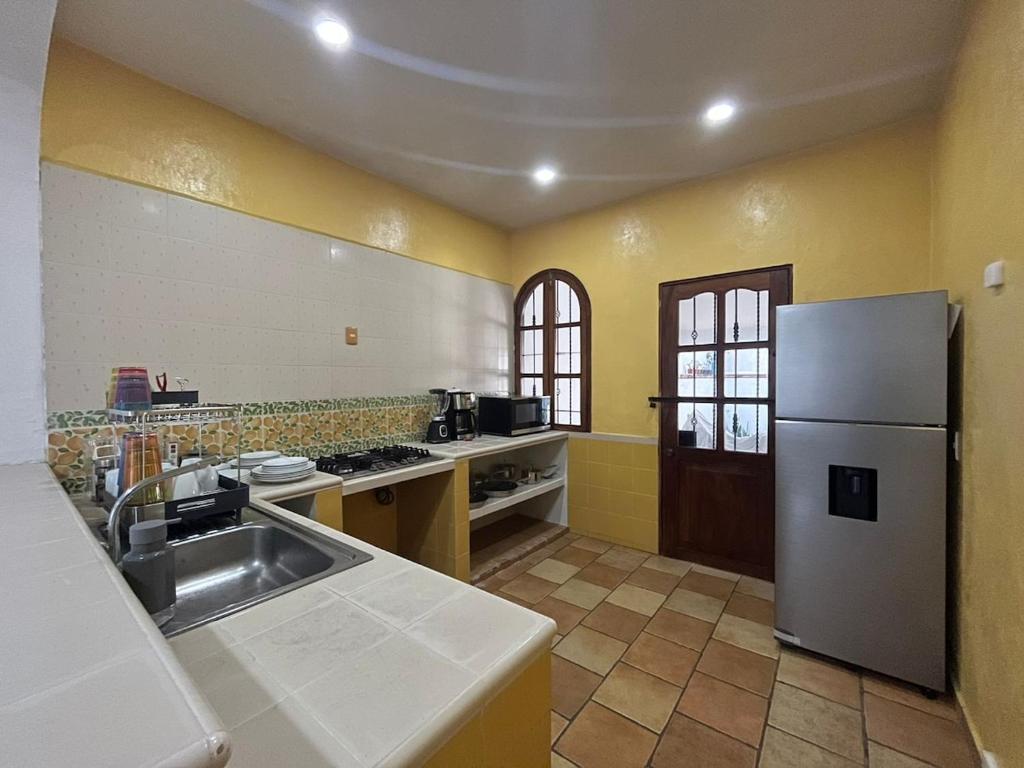 uma cozinha com pia e geladeira em Casa ola Rinconada Piscina Starlink 5 min caminando a bahía Carrizalillo em Puerto Escondido