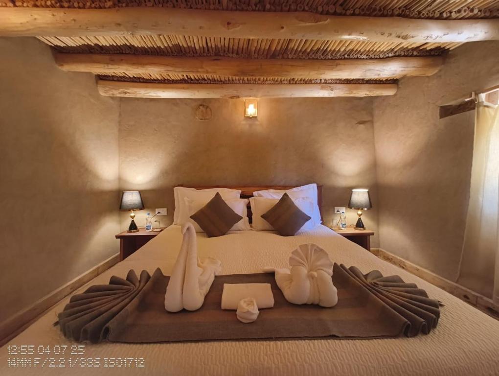 Saspul GömpaMoljoks Heritage House的一间卧室配有一张带两个天鹅的床