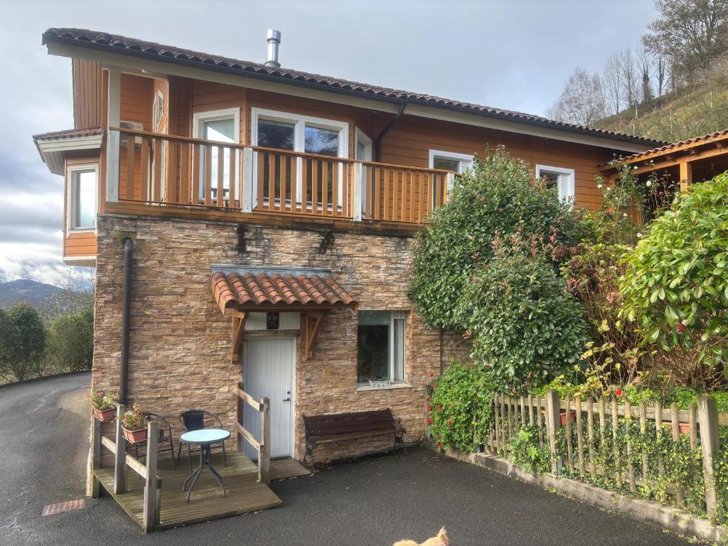 a brick house with a balcony on top of it at Arbegain Etxea in Aizarna
