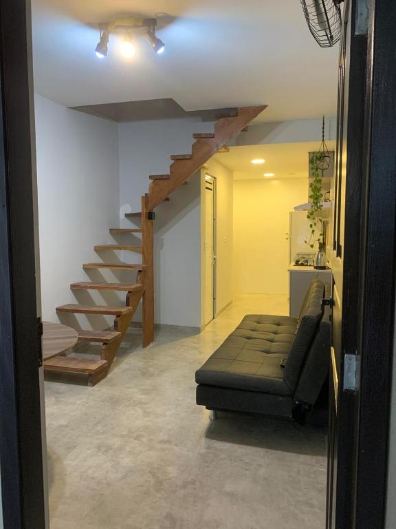 a living room with a staircase and a couch at Sobradinho Riviera, 3 Quadras do Mar - COM AR CONDICIONADO no quarto in Matinhos