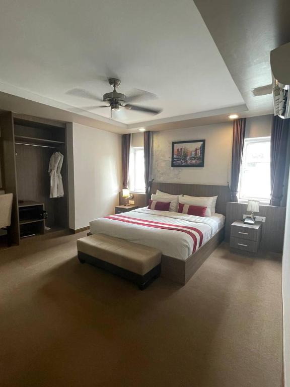 a large bedroom with a bed and a ceiling fan at Clover Hotel in Phumĭ Prêk Chrey