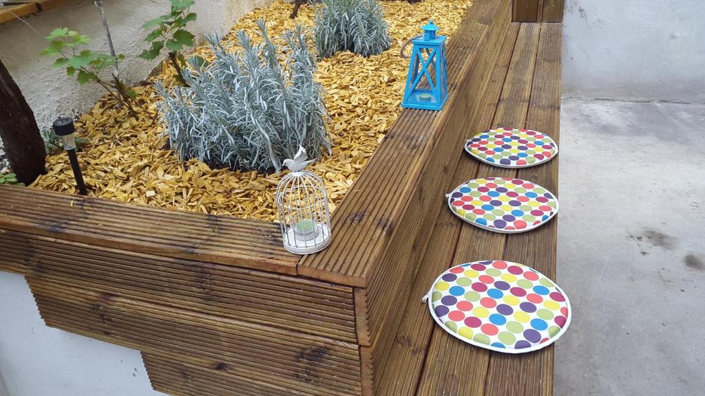 a wooden bench with plates on it in a garden at Apartments Belvedere in Rijeka