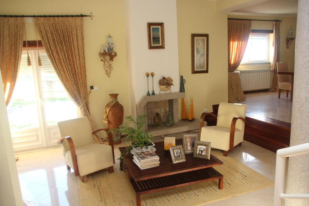 uma sala de estar com uma mesa e cadeiras e uma lareira em Quartos em vivenda serra da Estrela em Celorico da Beira