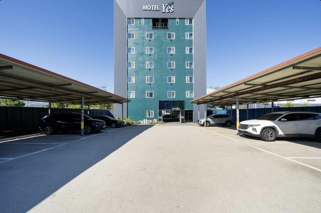 Gunsan Yes的酒店门前设有停车场,可停放汽车