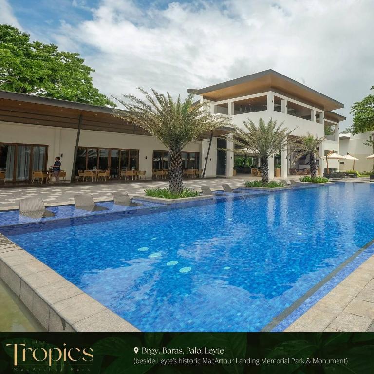 una gran piscina frente a una casa en The Tropics at MacArthur Park, en Palo