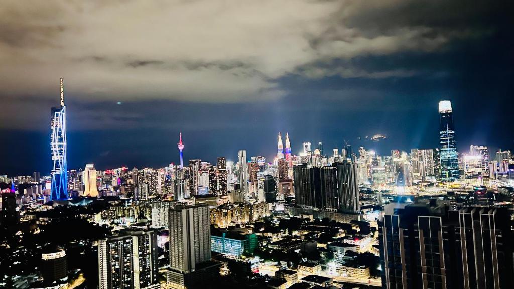 TRION KL Sky Suites KLCC View في كوالالمبور: اطلاله على مدينه كبيره بالليل