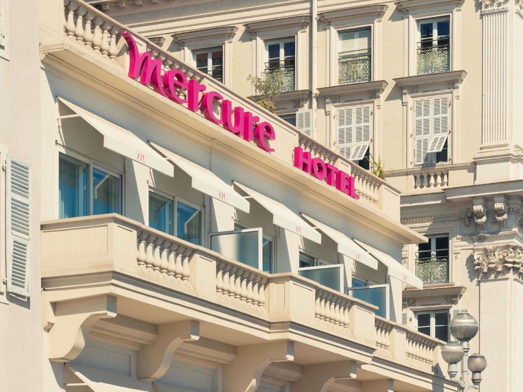a hotel with a sign on the side of a building at Mercure Nice Marché Aux Fleurs in Nice