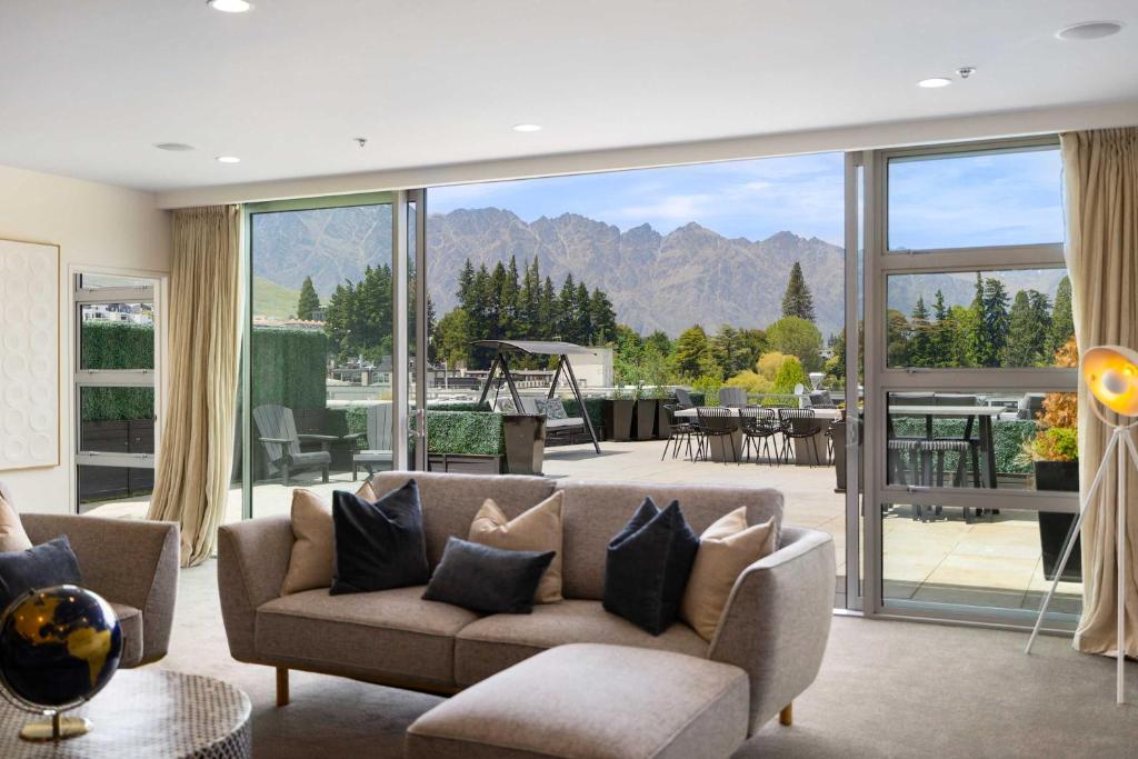 THE SHOTOVER Central Queenstown Luxury في كوينزتاون: غرفة معيشة مع أريكة ونافذة كبيرة