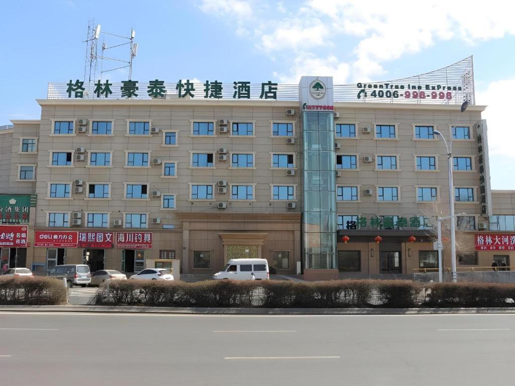Green Tree Inn Urumqi San'gong Metro Station Exit في أورومكي: مبنى كبير مع لافتة فوقه