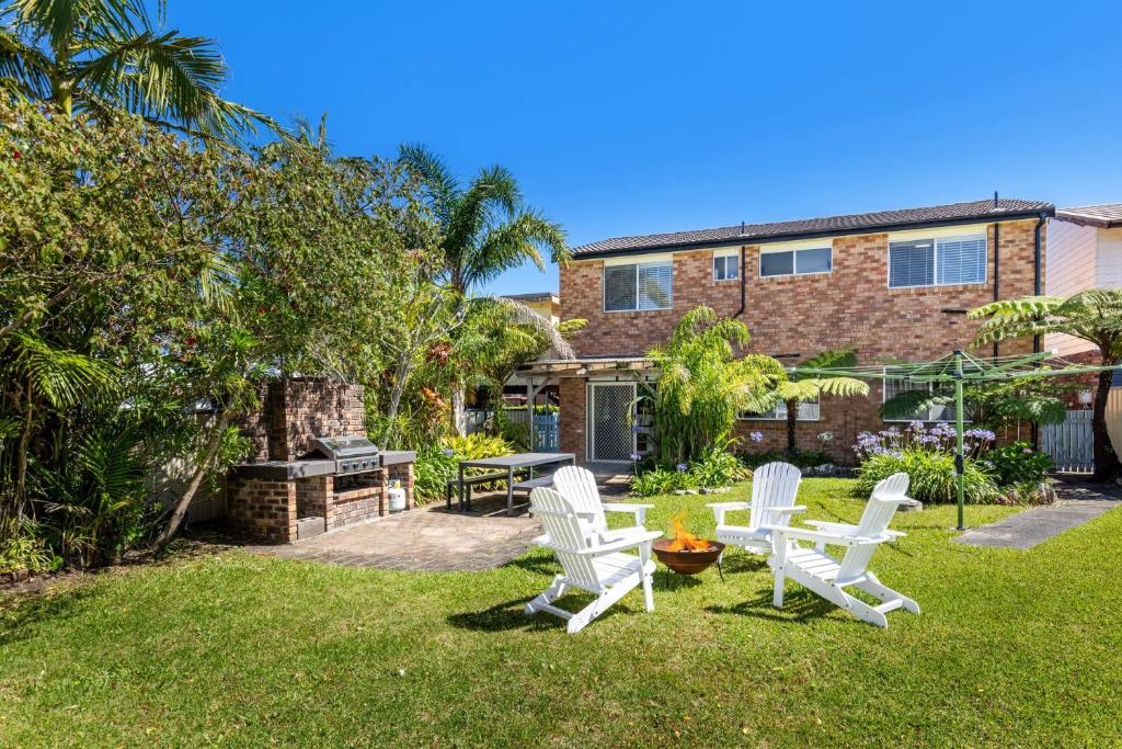 een groep witte stoelen en een tafel in een tuin bij Sommaroy - Pet Friendly with Fire Pit in Currarong