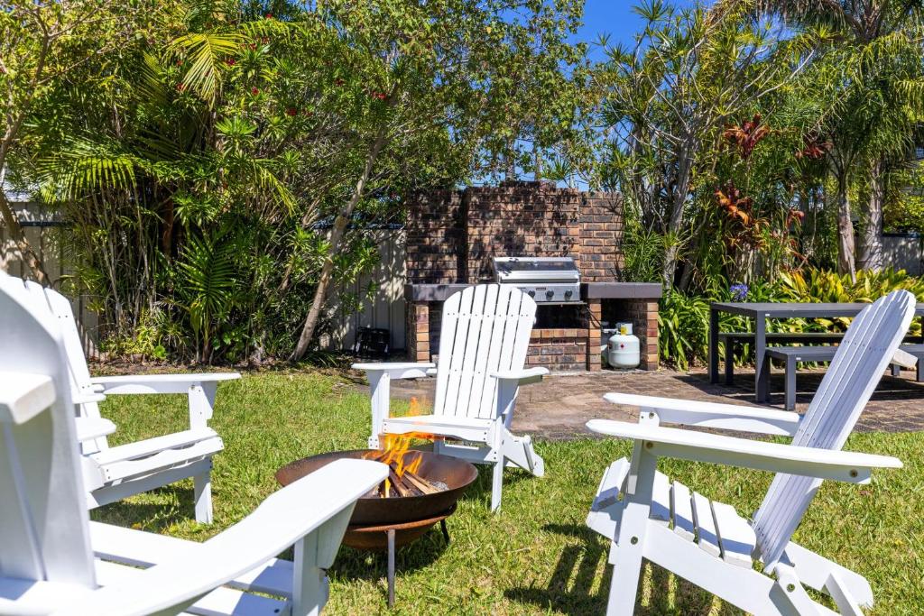 a group of white chairs sitting in the grass at Sommaroy - Pet Friendly with Fire Pit in Currarong