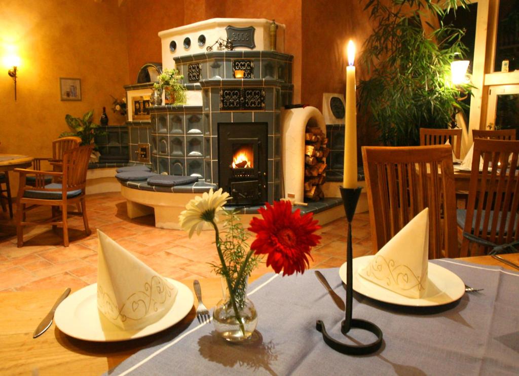 a table with two plates and a fireplace in a restaurant at Landhotel "Lichte Aue" Lichtenau in Stützengrün