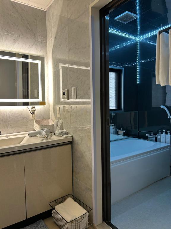 a bathroom with a tub and a sink and a bath tub at 那覇国際通り徒歩圏内Okinawa 住宅風ゲストルーム in Naha