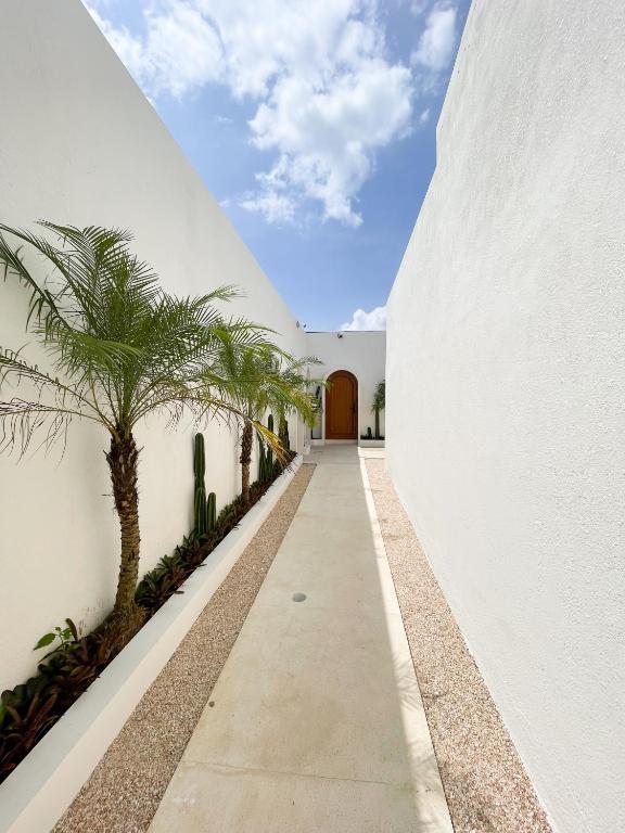 un pasillo con palmeras en el lateral de un edificio en Staycationku Premium Jogja Villas, en Beran-kidul