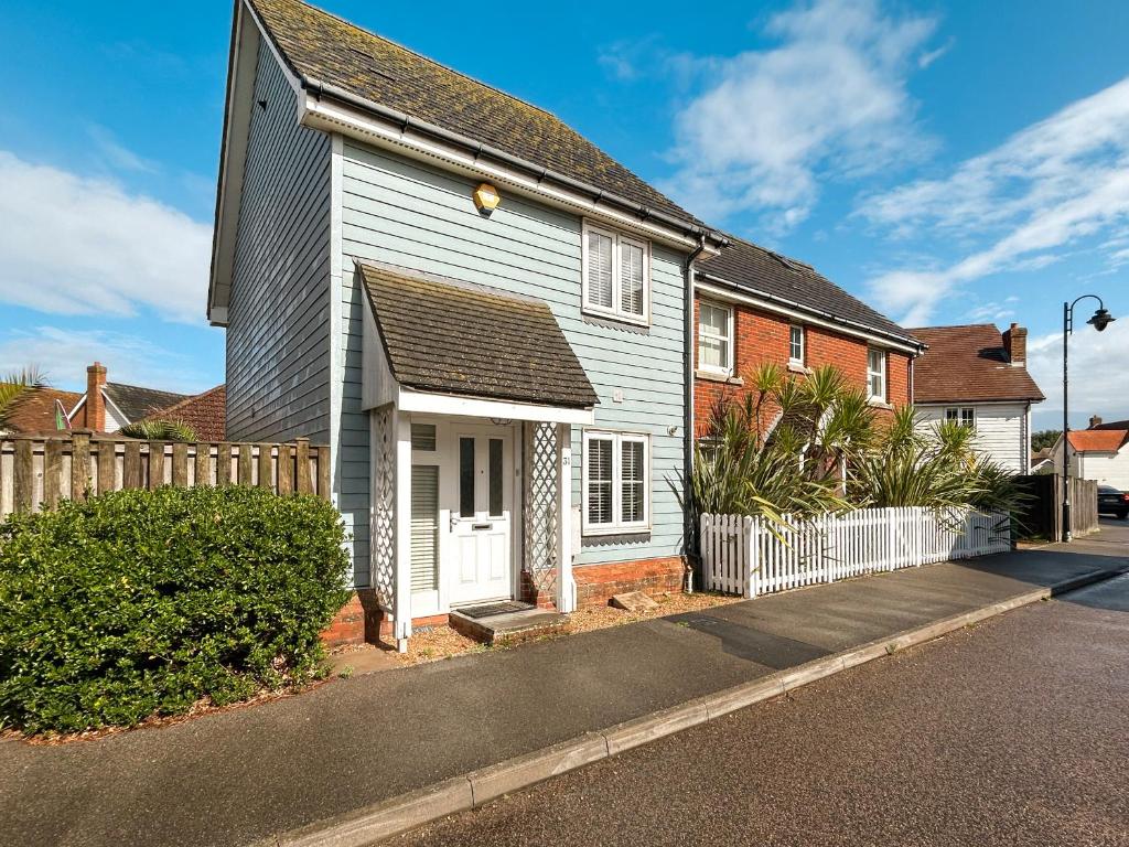 une maison avec une porte blanche et une clôture dans l'établissement Dory, à Camber