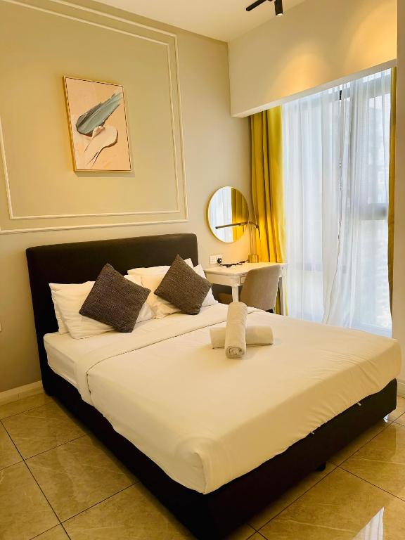 Un dormitorio con una gran cama blanca con ventana. en Bukit Bintang Suites KL, en Kuala Lumpur