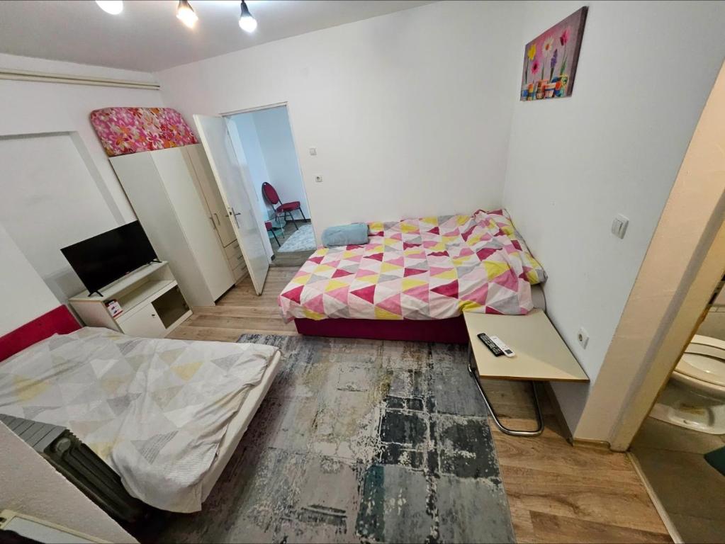 a room with a bed and a desk in it at Apartman u centru Prnjavor in Prnjavor