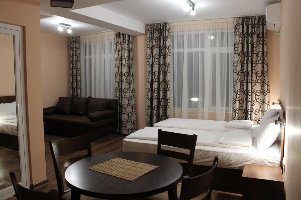 Habitación con cama, mesa y sofá en Center Guest House en Sapareva Banya
