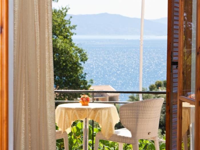een tafel en stoelen op een balkon met uitzicht bij Valedina Rooms in Nikiana