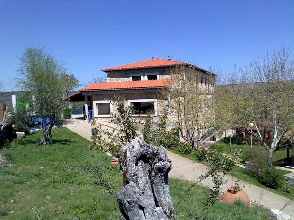 una casa con un tronco de árbol delante de ella en Camping Al-Bereka en La Alberca
