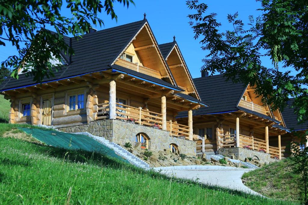 a large log cabin with a pathway in front of it at Domki Prokop in Ciche