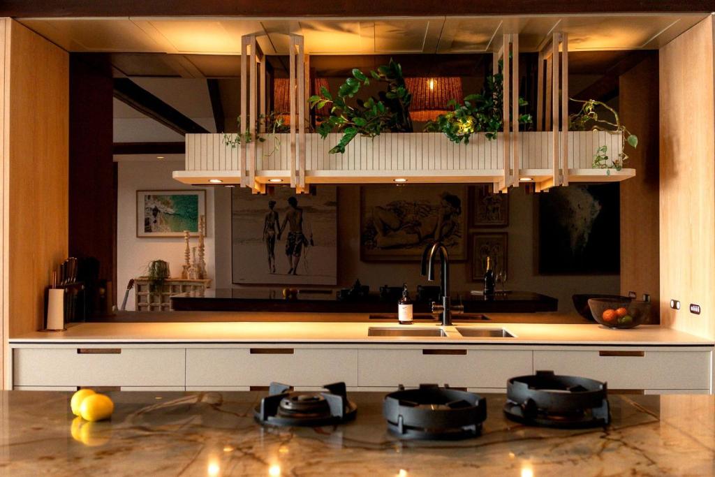 Luxury On The Bay - 2 x 3 bedroom apartments في خليج بايرون: مطبخ مع كونتر توب مع قدور ومقالي