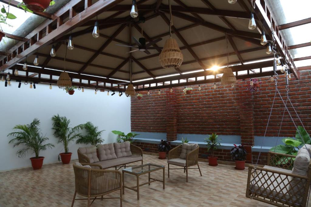 a living room with a couch and chairs and a brick wall at The Loft -Aadhya Homestay Hampi in Munirābād