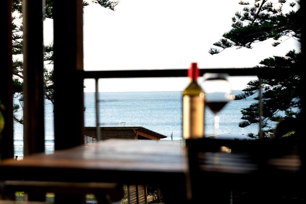 a view of the ocean from a table with a bottle of wine at Luxury On The Bay 1 in Byron Bay