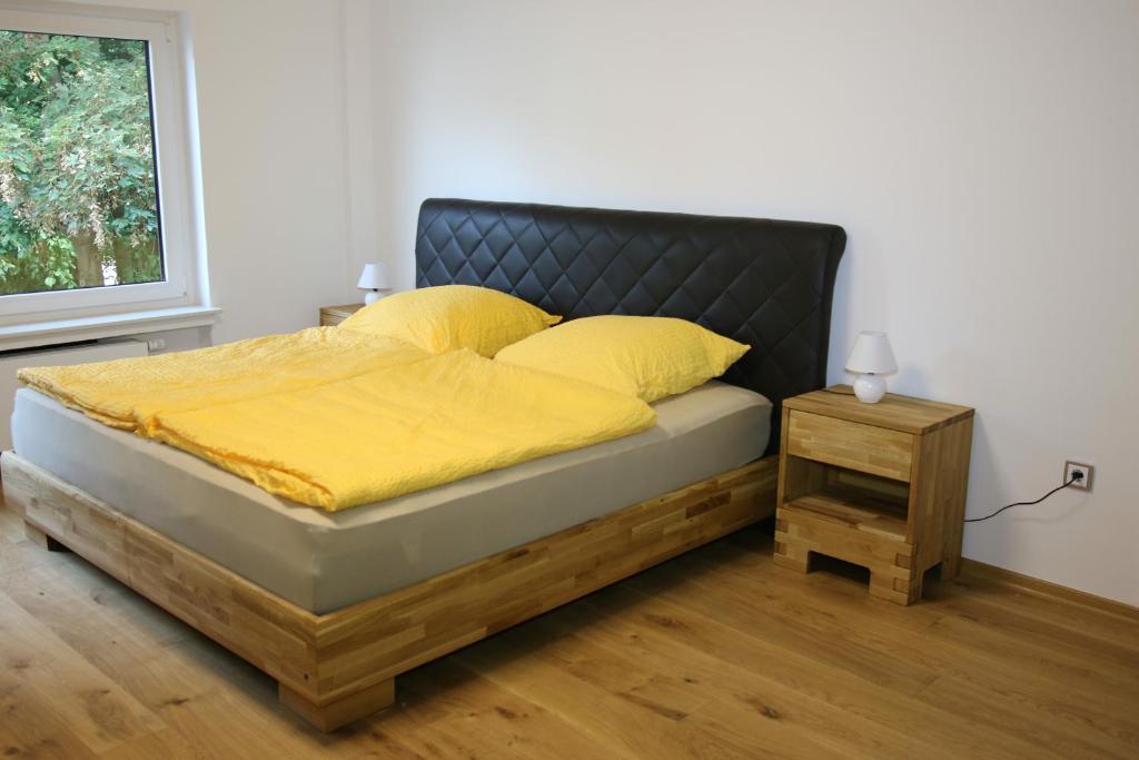 a bedroom with a bed with yellow sheets and a side table at Vlotho Apartment in Vlotho