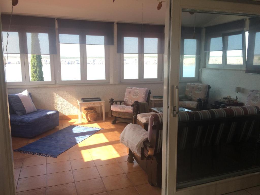 salon z kanapą, krzesłami i oknami w obiekcie Apartment Gigi w mieście Jadranovo