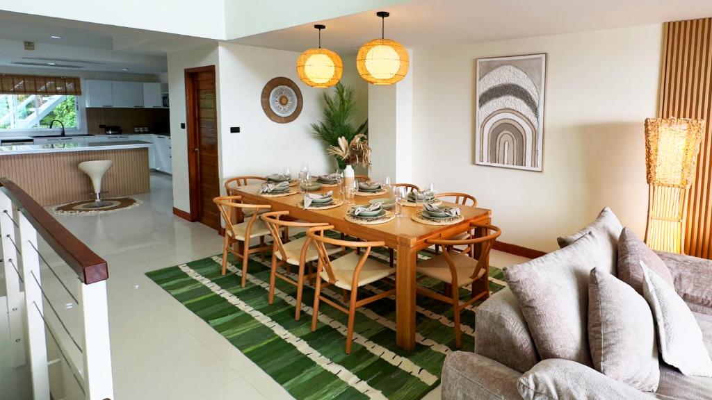 a dining room table and chairs in a living room at Mali Villa 57 in Patong Beach