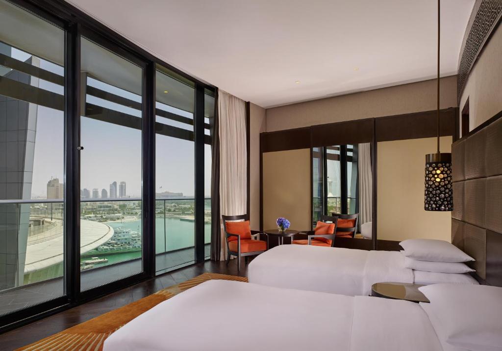 a bedroom with two beds and a view of a pool at Grand Hyatt Abu Dhabi Hotel & Residences Emirates Pearl in Abu Dhabi