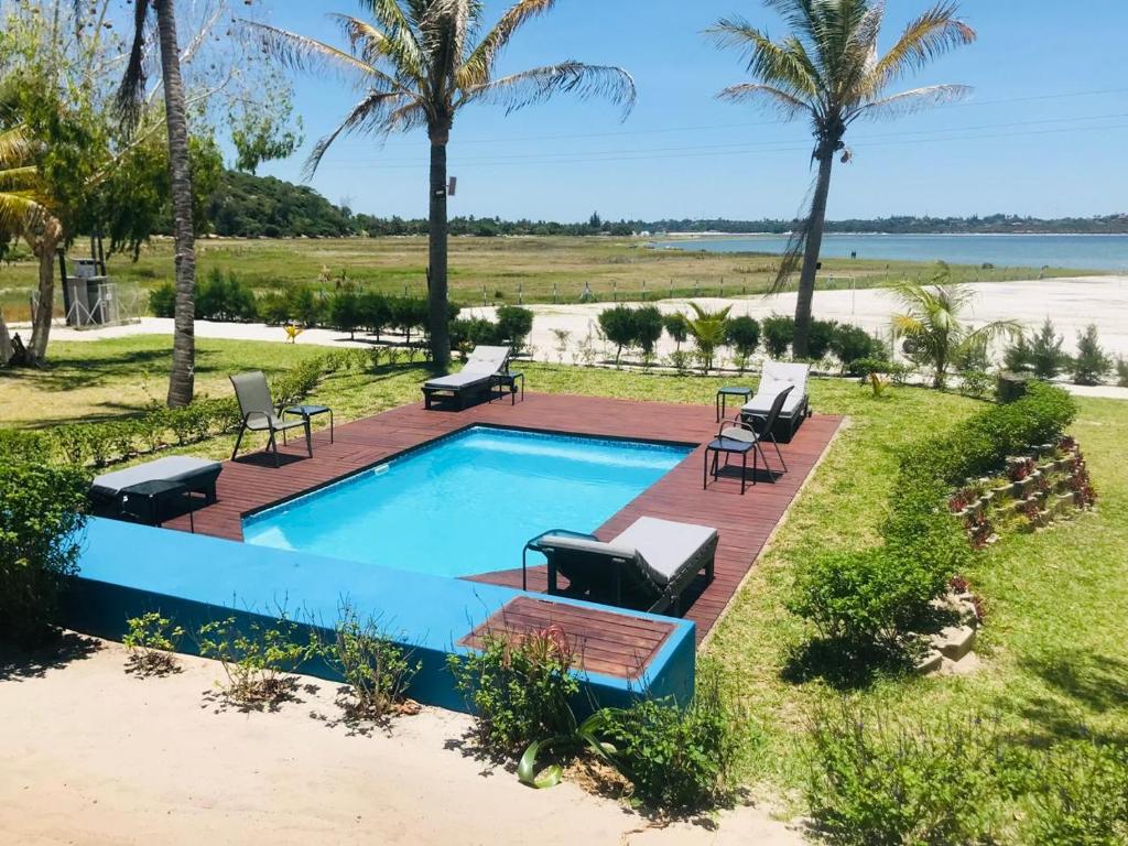 una piscina con tumbonas junto a la playa en Blackstone Sands Resort Bilene, en Vila Praia Do Bilene