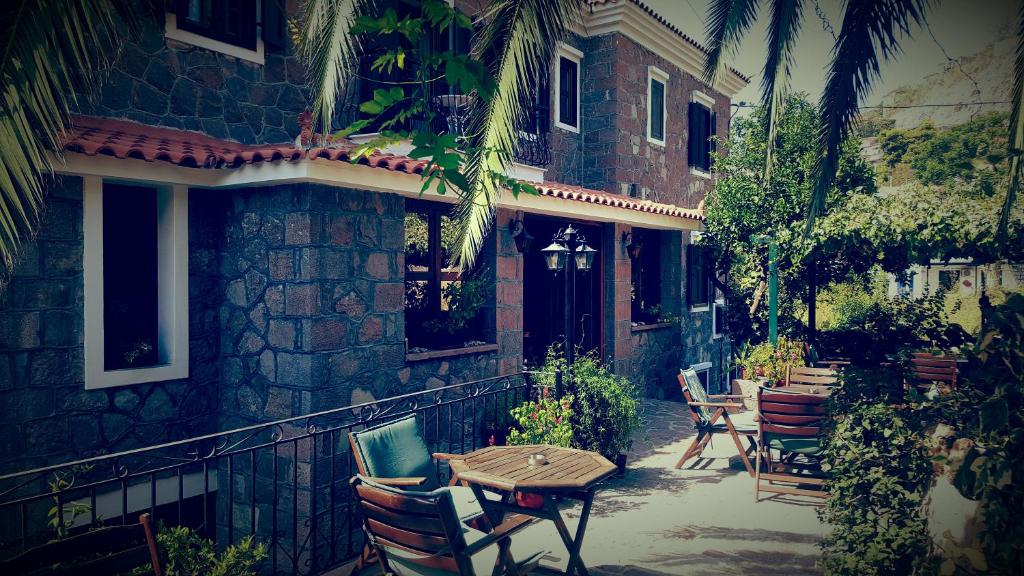 Hotel Adonis في ميثيمنا: فناء به طاولة وكراسي أمام مبنى