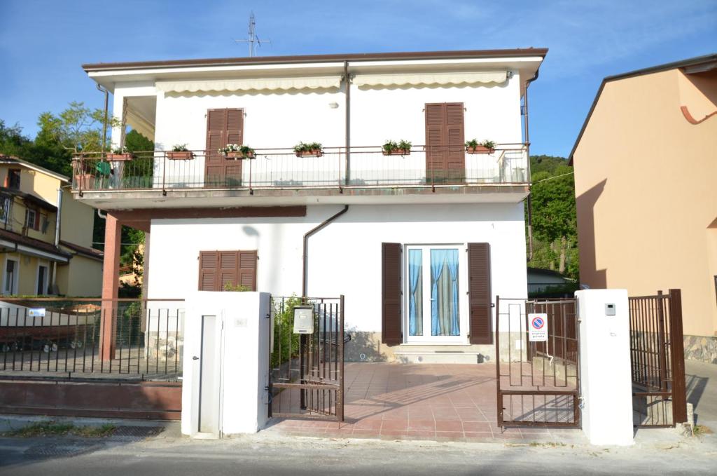 Casa bianca con balcone e cancello di La Perla del Magra Holidays House a Monte Marcello