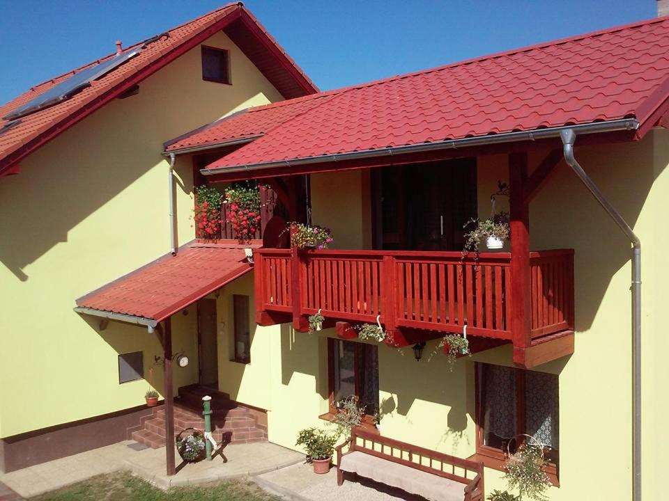 una casa con un balcón rojo con macetas. en Ubytovanie Zuzana, en Smižany