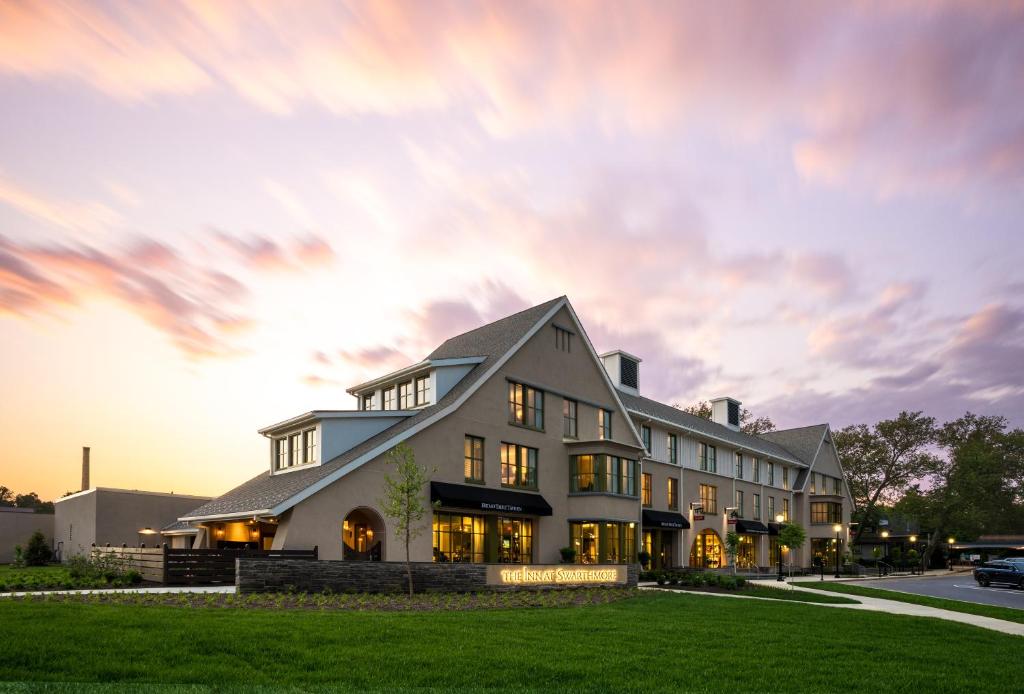 a large white building with a sunset in the background at The Inn At Swarthmore in Swarthmore