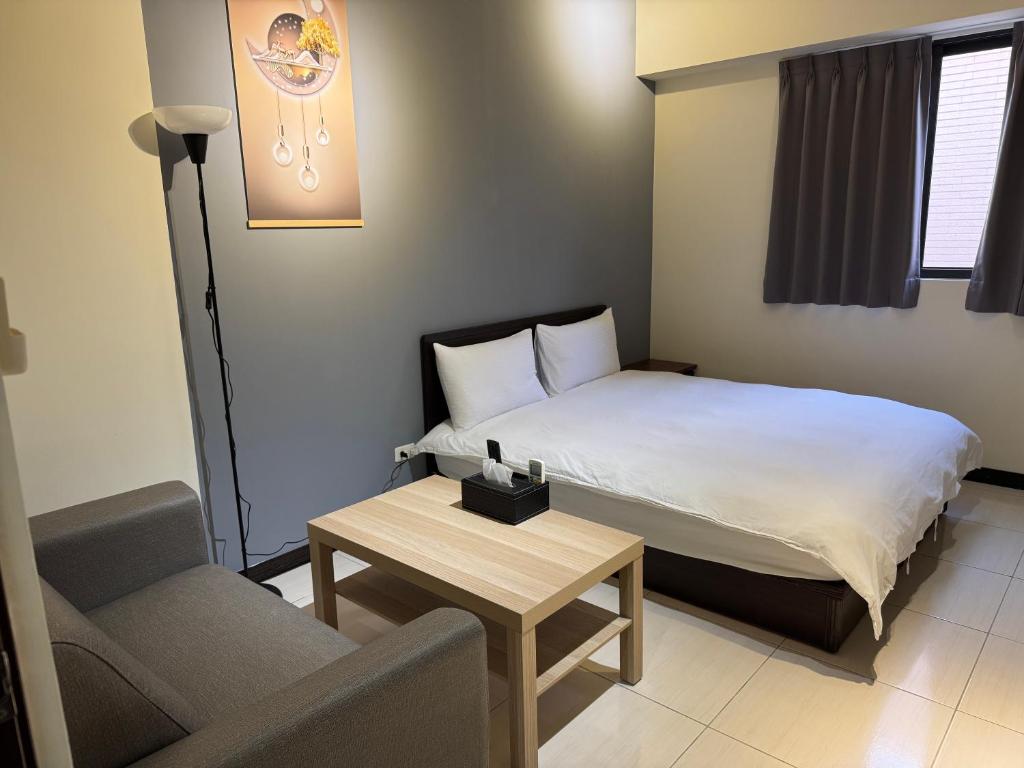 a bedroom with a bed and a couch and a table at 台中向日葵 in Taichung