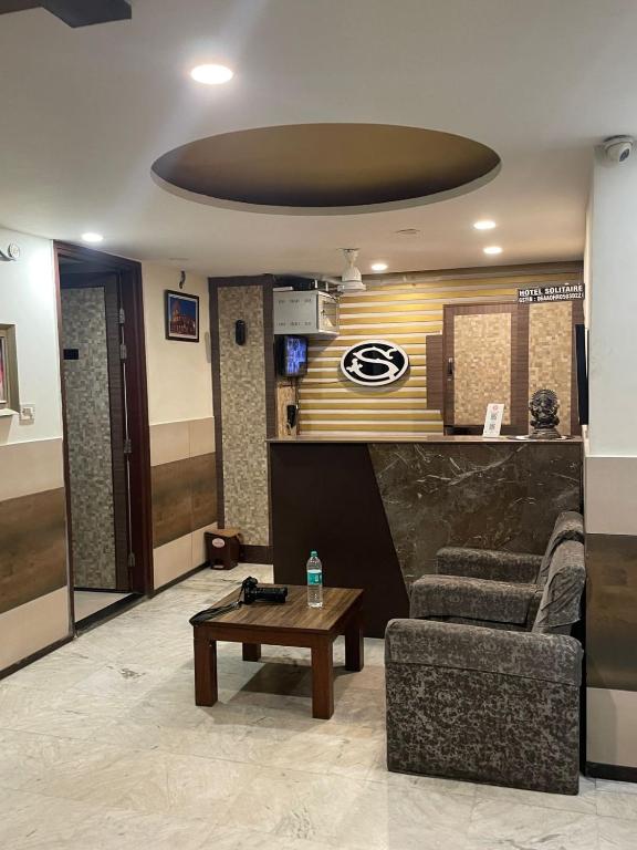 a living room with a couch and a table at Hotel Solitaire in Ambāla Cantonment