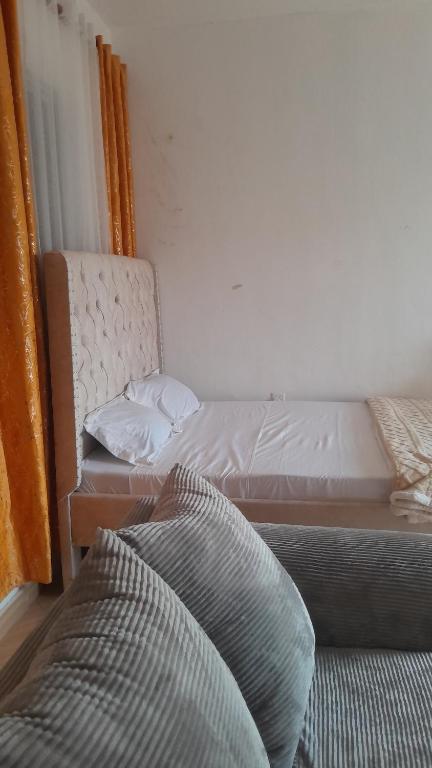 Little Haven في ماليندي: غرفة نوم بها سريرين وأريكة بداخلها