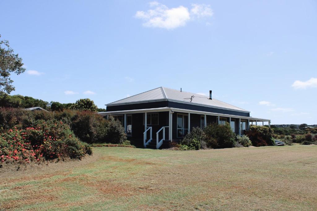 a large building with a large yard in front of it at The Yanakie House & Cabins in Yanakie