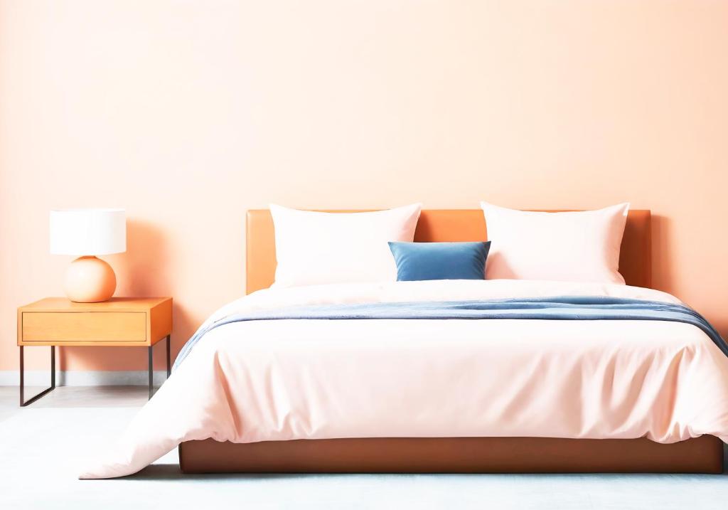 uma cama com lençóis brancos e almofadas azuis em The Banana Cottage em Udawalawe