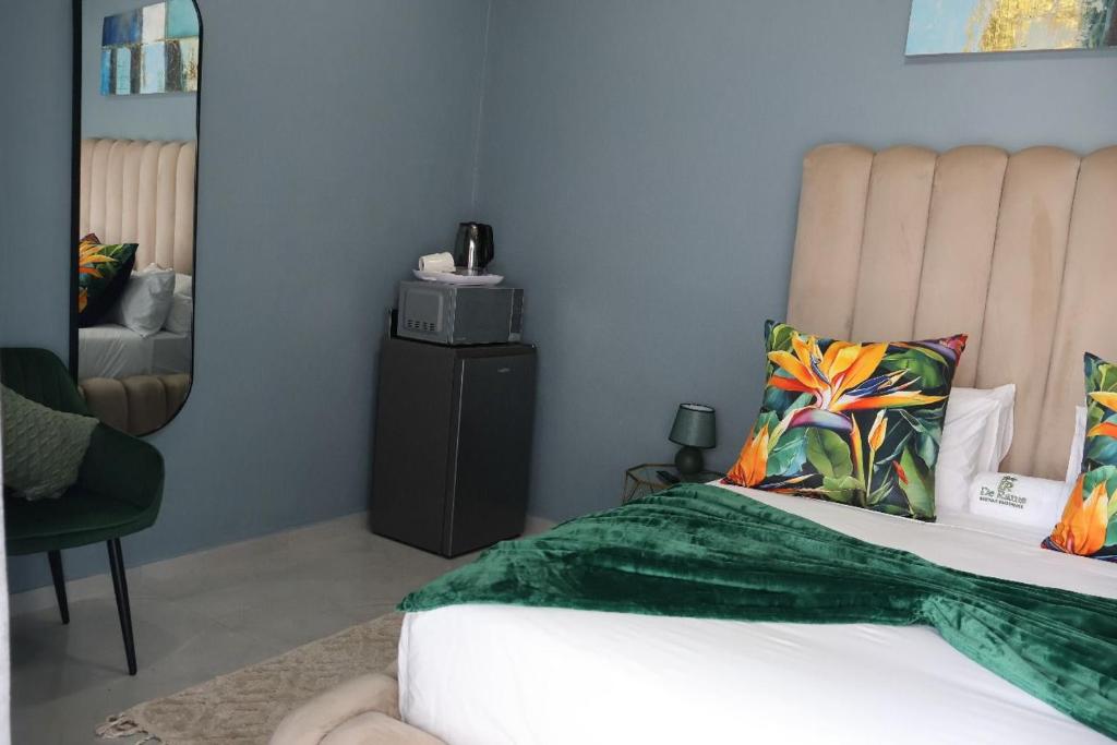 De Rams boutique guest house : غرفة نوم بها سرير وكرسي ومرآة