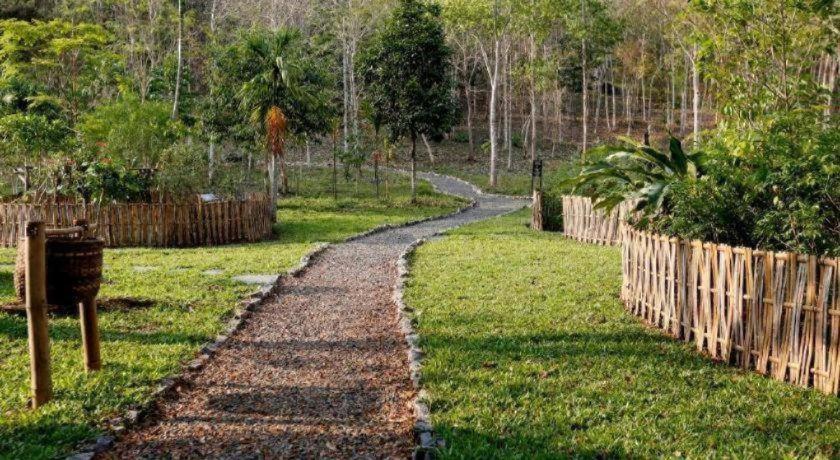 a path in a yard with a wooden fence at Mylaohome Guesthouse & Spa in Luang Prabang