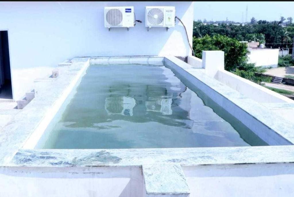 a swimming pool on the side of a house at Hotel O Royal Inn Hotel in Hāpur