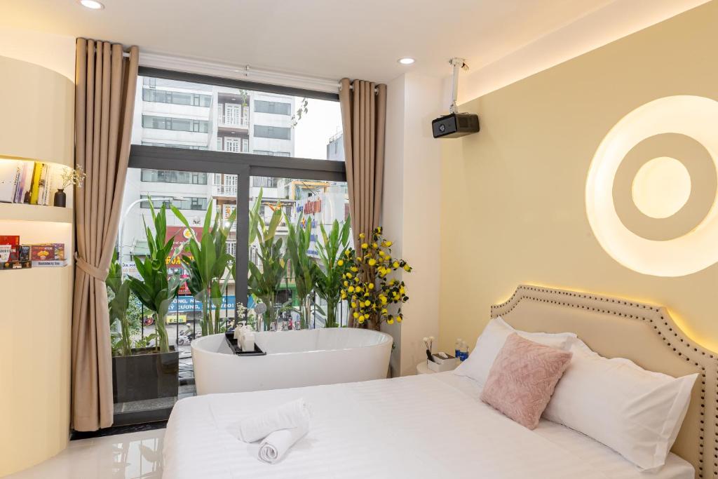 a bedroom with a bed and a bath tub and a window at Ori Home in Ho Chi Minh City