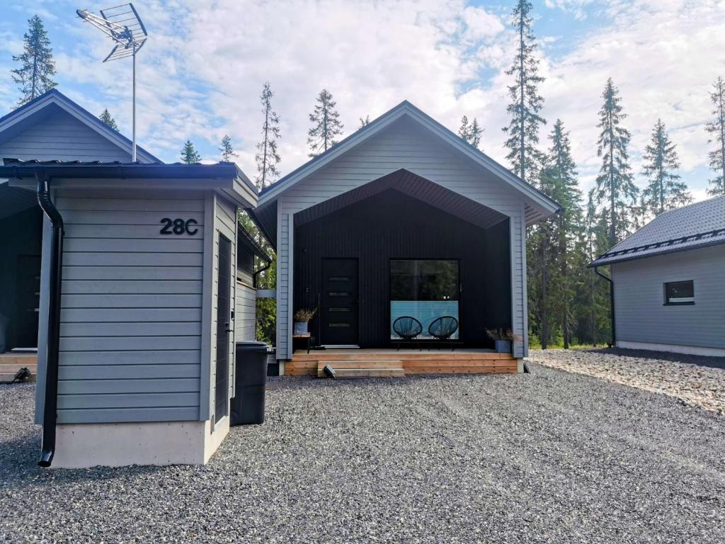 Un cobertizo negro con un porche y una casa. en Villa Anilia, en Syöte