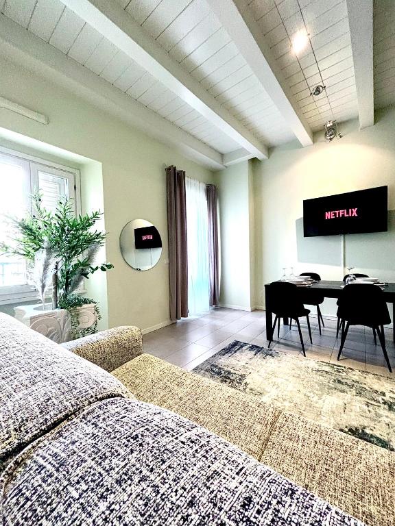 een woonkamer met een bed, een tafel en een televisie bij Nido di Rossini in Pesaro